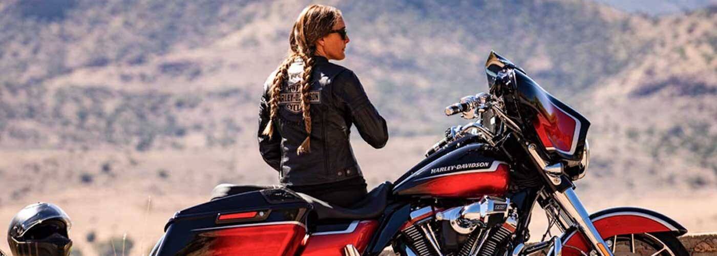 Woman in Harley-Davidson Jacket Standing Next to Bike