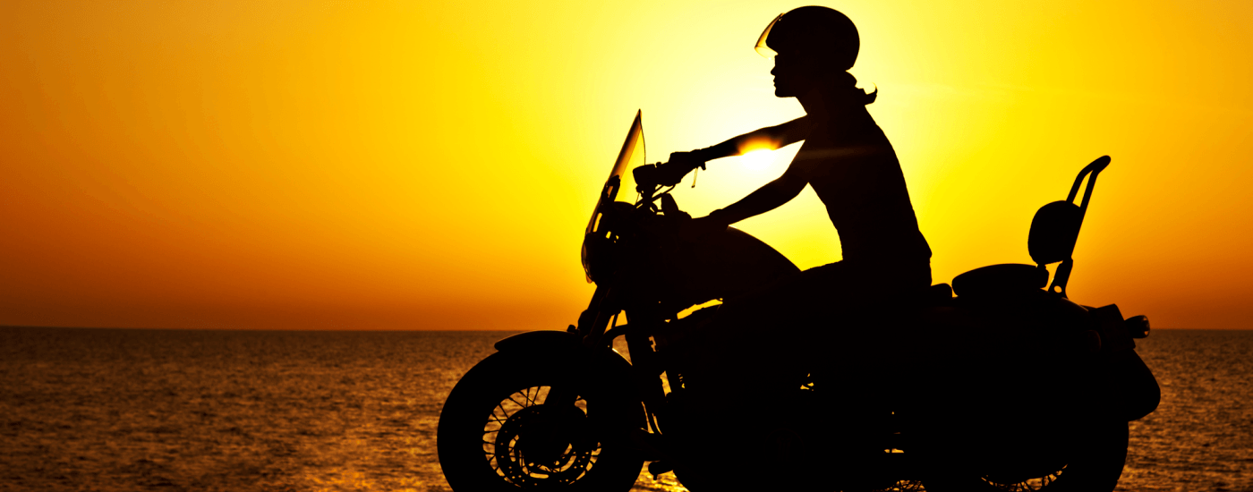 Woman on a motorcycle at sunset