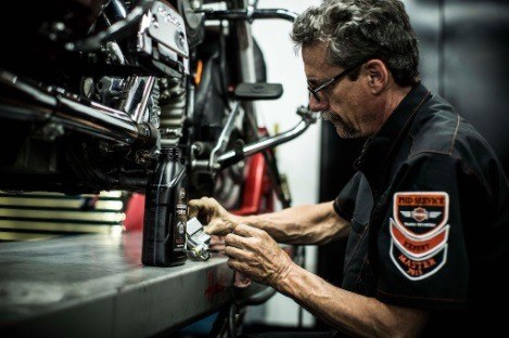 Master tech doing a bike service on a Harley-Davidson motorcycle.